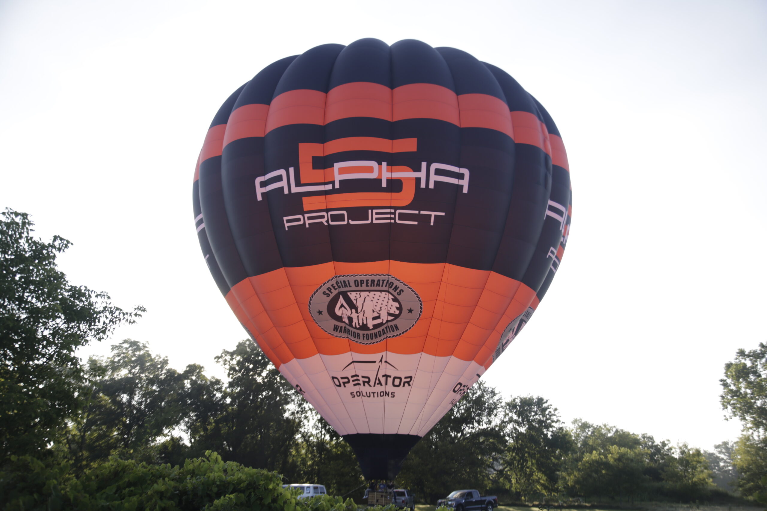 Cameron A-560 hot air balloon with Alpha 5 branding on ground