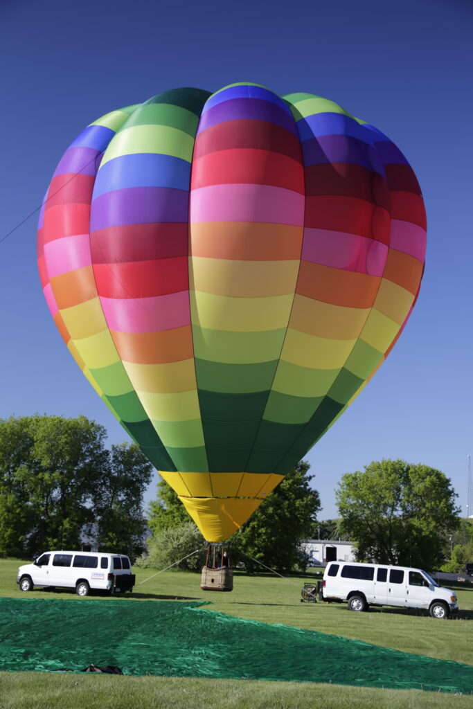 Cameron O-105 hot air balloon on ground with bright sky