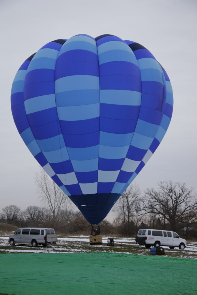 Cameron O-105 hot air balloon on ground with melting snow