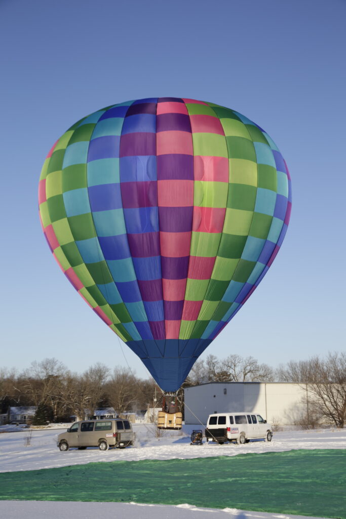 Cameron Z-77 hot air balloon tethered on sunny day with snow covered ground