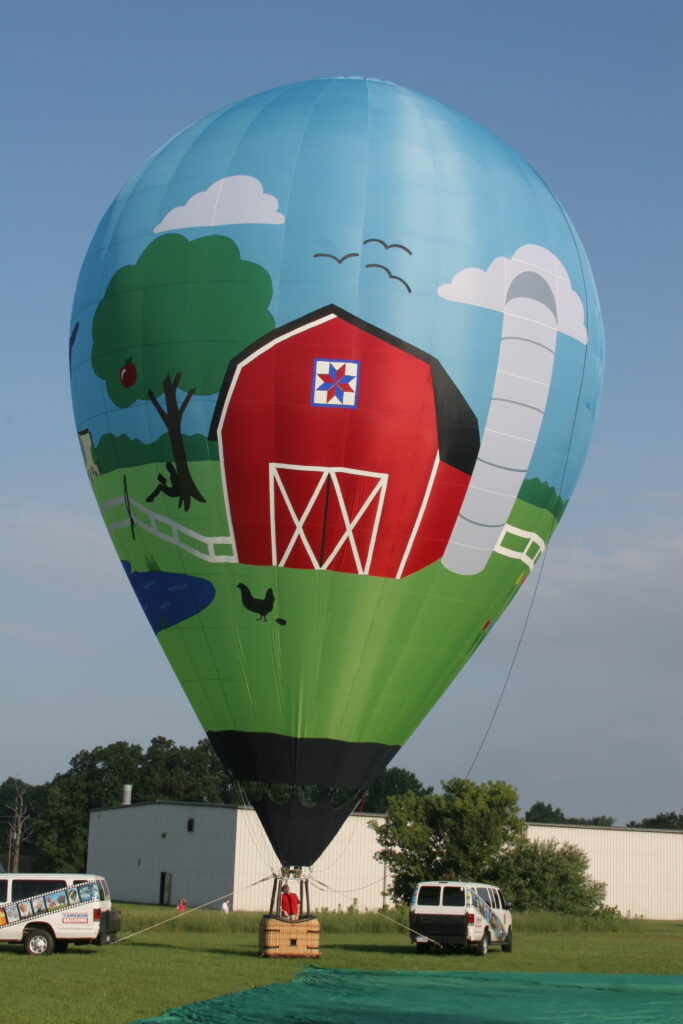 Cameron ZL-70 racer hot air balloon with custom farmland artwork on ground