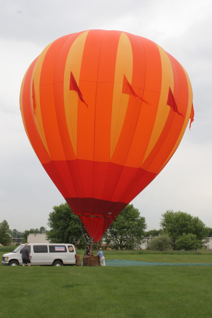Cameron C-80 hot air balloon with red pennants inflated on ground