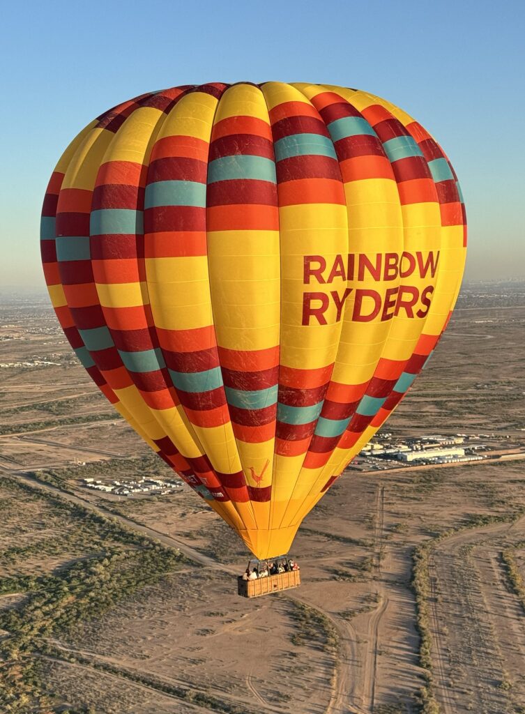 Cameron A-375 hot air balloon in flight over a desert landscape