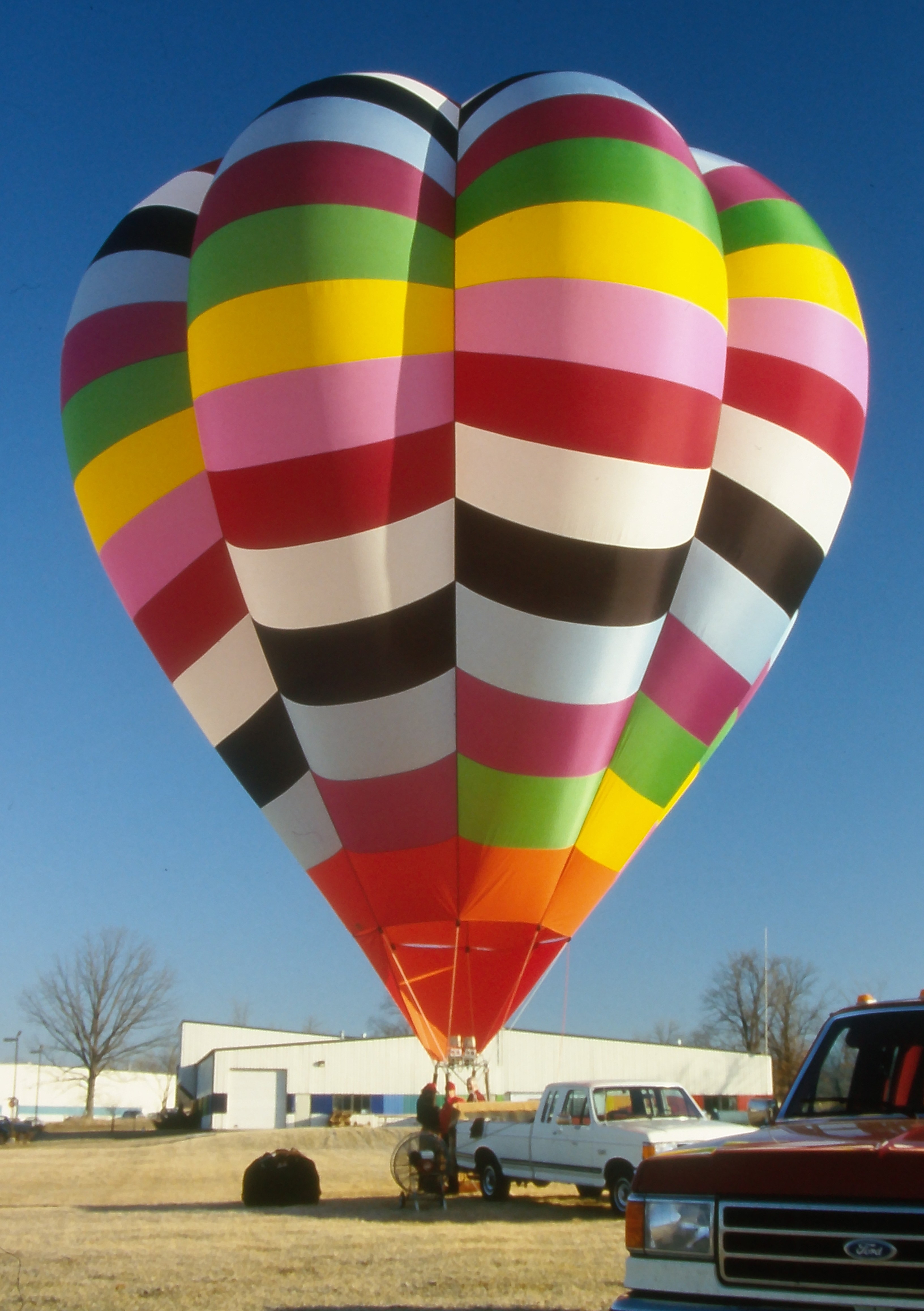 Cameron V-65 hot air balloon with multicolored pattern on ground