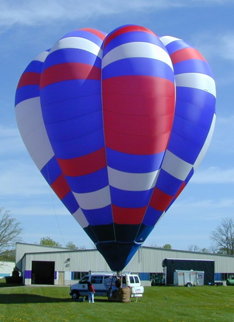 Cameron V-77 hot air balloon with patriotic color pattern on ground